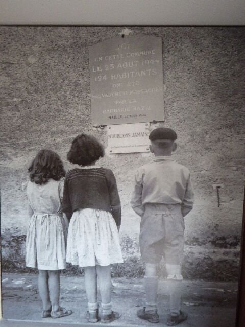 Drei Kinder vor der Gedenktafel am Rathaus (© Maison du Souvenir)