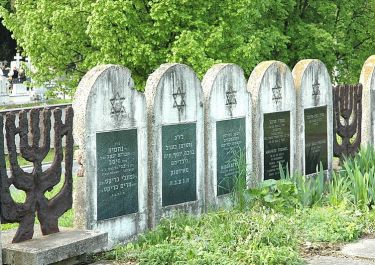 symbolische Grabsteine fassen den Friedhof ein